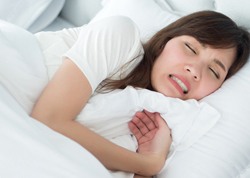 A woman asleep and clenching her teeth