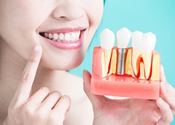 Woman holding dental implant in Juno Beach