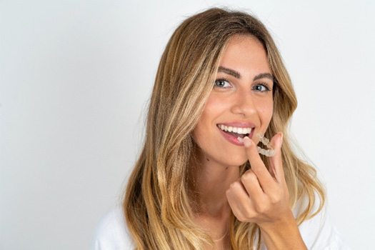 A woman with an Invisalign tray near The Bluffs in Jupiter