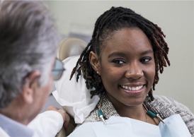 A dentist in Juno Beach talking with a female patient about her oral health