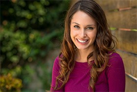 A woman smiling outside