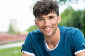 A teenager smiling outside.