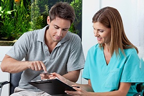 A man paying the cost of cosmetic dentistry