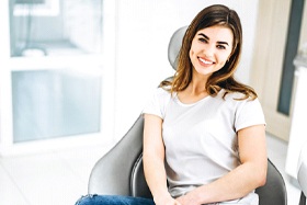 young brunette woman smiling in dental chair 