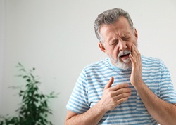 Man with mouth pain, concerned about his dental implants