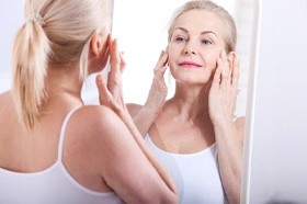 older woman looking in mirror