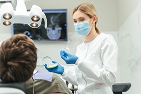 Dentist showing patient clear aligner in treatment room