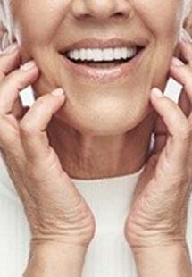 Close up of a smiling woman touching her face