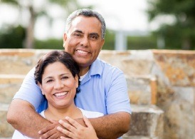 An older couple smiling and hugging.