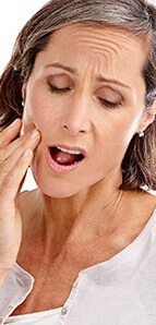 Woman in pain holding jaw