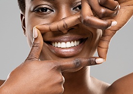 A beautiful black woman framing her healthy white teeth