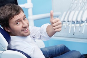 man smiling in his dental chair thanks to the jupiter dentist