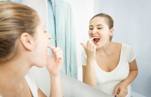 woman picking food out teeth