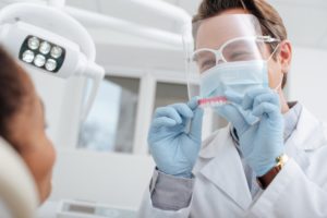 smiling dentist near Jupiter wearing mask and face shield