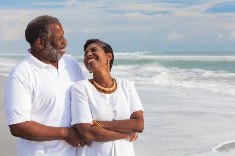 an older couple walking along the beach together after receiving dental implants in Juno Beach