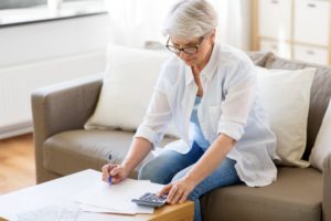 Senior woman looking at in-house dental savings plan paperwork