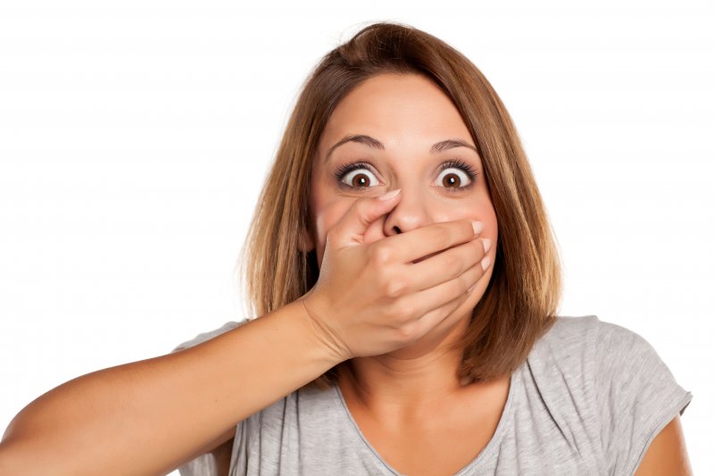 woman with hand over mouth