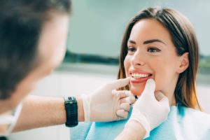 Woman smiling while receiving cosmetic dental work. 