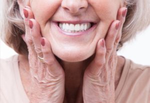 a woman smiling after getting rid of her dentures sores