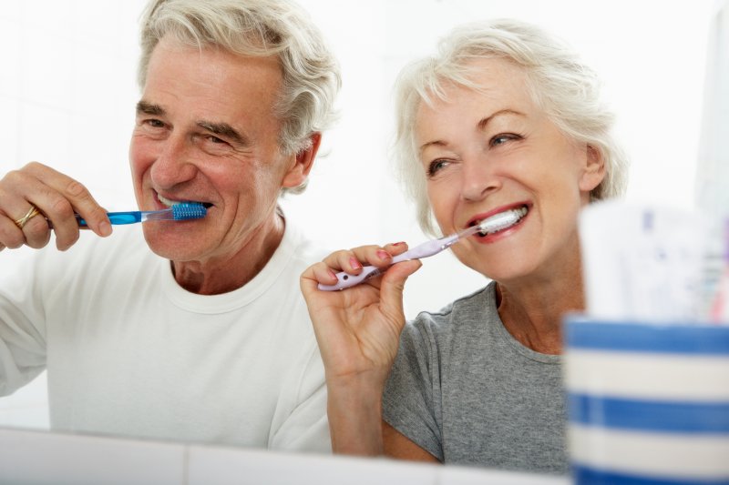 an older couple brushing their teeth