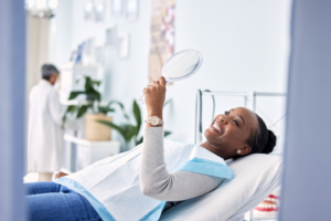 a patient smiling in a handheld mirror