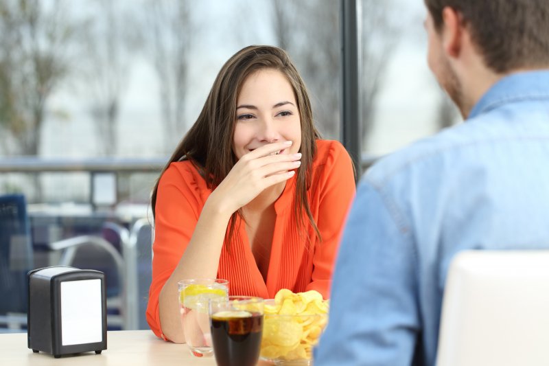woman hiding her smile on a date