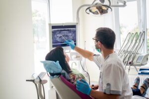Dentist showing patient X-ray of their teeth.